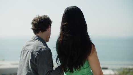 Back-view-of-young-couple-enjoying-breathtaking-sea-view.